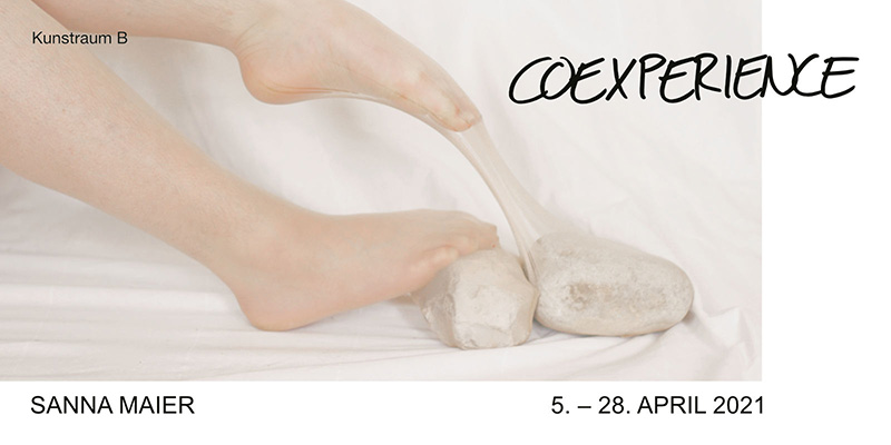 Ein Ausstellungsflyer zeigt nackte Füße auf einem hellen Tuch, die Steine berühren, daneben der Titel "COEXPERIENCE" und Ausstellungsdetails.