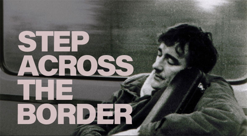 Ein Schwarz-Weiß-Filmposter für "Step Across the Border" zeigt im Vordergrund groß in Rosa den Titel und im Hintergrund eine verschwommene Aufnahme eines schlafenden Mannes mit geschlossenen Augen, der seinen Kopf auf eine Tasche lehnt.