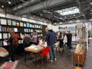 Gäste betrachten die Publikationen und den Stand der Muthesius Kunsthochschule bei der Leipziger Buchmesse