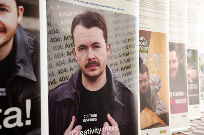 Ausstellungsansicht mit Messeschildern, auf denen Social-Media-Beiträge gezeigt werden