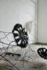 Ausstellungsansicht einer Installation mit Radkappen und Drähten