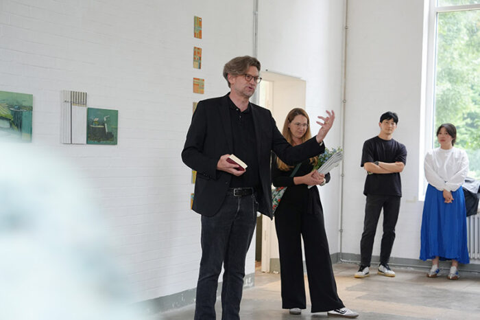 In einem Ausstellungsraum spricht eine Person vor Publikum