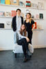 Drei Personen stehen und sitzen in einem Studio in einer Kunsthochschule